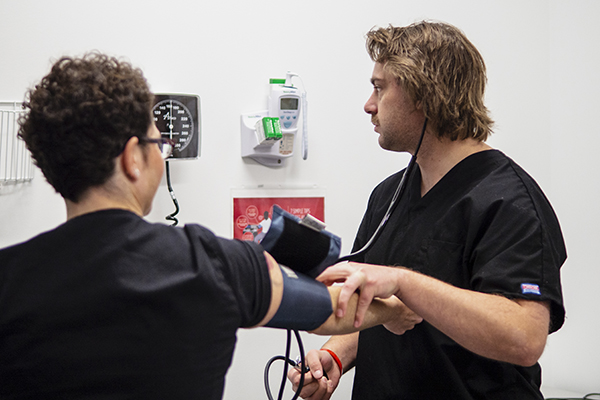 Medical assistant student practices taking blood pressure