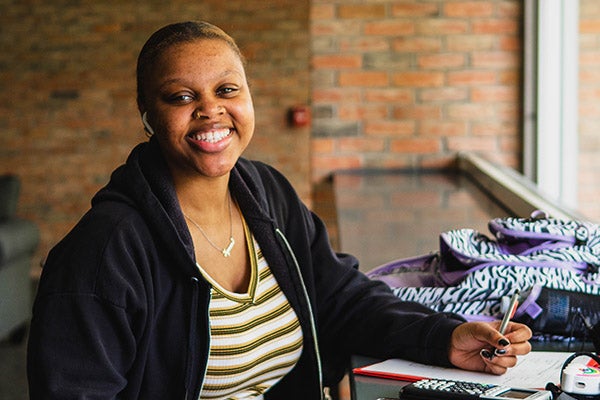 Female student smiles while working.