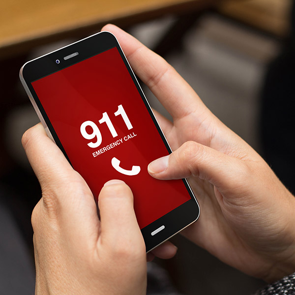 Hands hold phone displaying "911 emergency call" on screen.