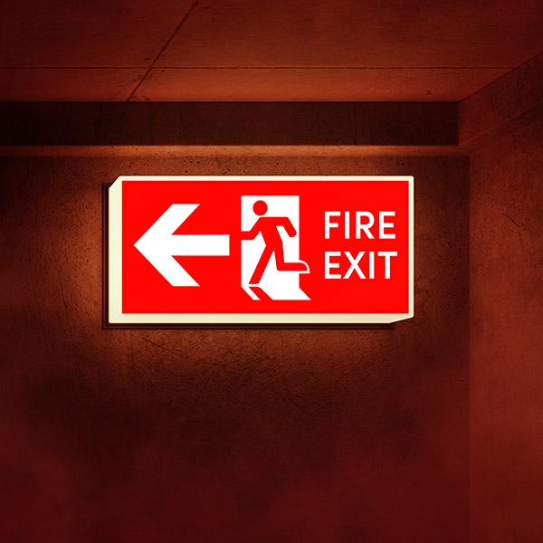 Illuminated Fire Exit sign in hallway with smoke rising.