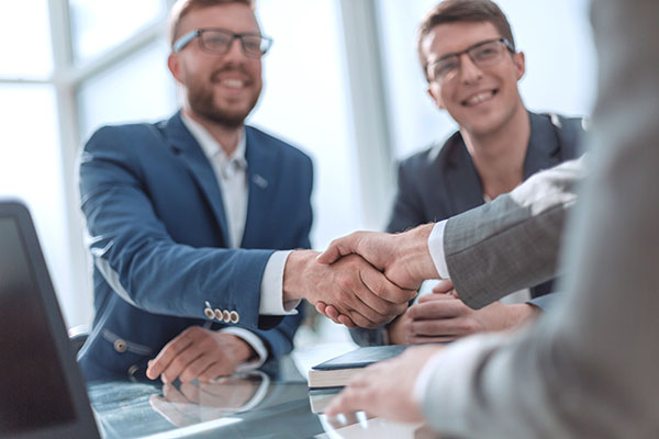 Business Professionals shaking hands to approve a deal