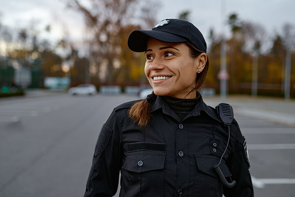 Portrait of smiling female police officer on street looking aside.