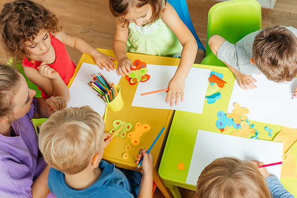 Kindergarten or preschool aged children being taught art lesson to aid in child development