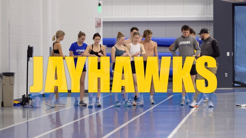 Track and Field athletes behind a Font that reads Jayhwaks.